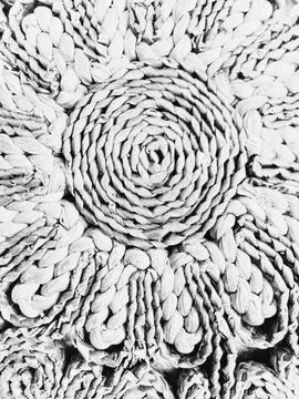 Rustic wicker trivet circular flower pattern background 库存照片