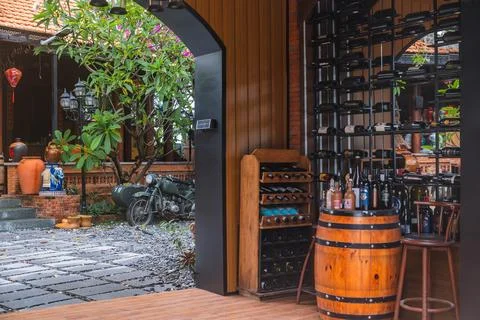 Rustic Wine Display with Vintage Motorcycle in Courtyard Foto stock