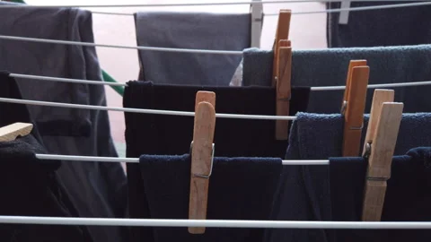 Rustic Wood Clothes Pegs Lined Up on a Drying Rack for Laundry Day 動画素材 291584719