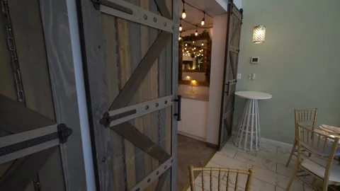 Rustic wooden barn doors open to a lit hallway in an event space Stock Footage 345552824