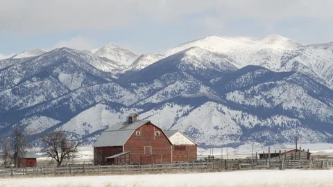 Rustic wooden barn in front of snowy mountains Stock Footage 113235547