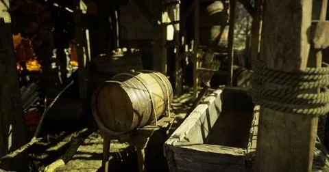 Rustic wooden barrel and empty trough inside a farm shed Illustrazione stock