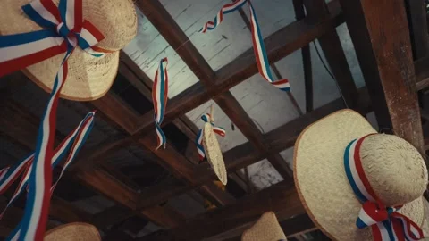Rustic wooden beams support hanging straw hats Stock Footage 337861887