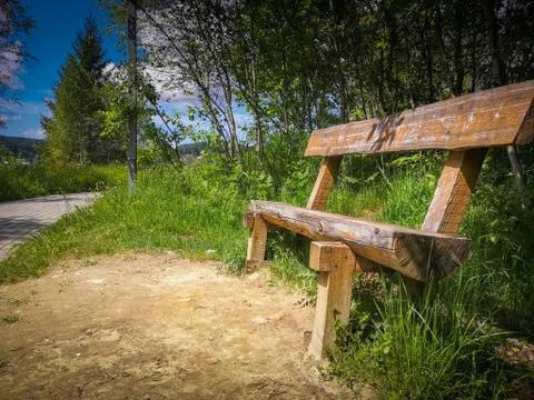 Rustic wooden bench in a park without people. Stock Photos