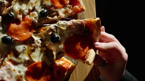 Rustic wooden board presenting melting pizza slice, revealing gooey mozzarella Stock Footage 301372445