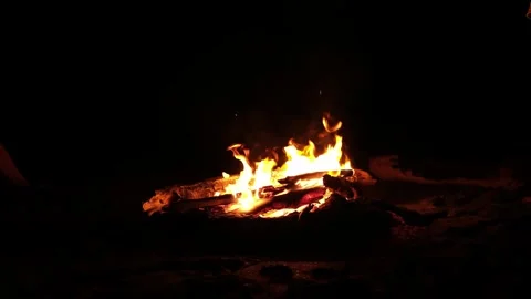 Rustic wooden bonfire burning with bright flames under the night sky. 库存影片 344159922