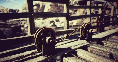 Rustic wooden bridge structure with pulleys and chains in a rugged landscape Stockillustratie