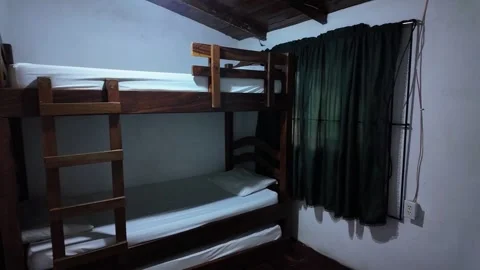 Rustic wooden bunk beds in a cozy mountain lodge guest room Stock Footage 332622872