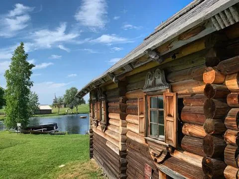 Rustic wooden cabin with open window in countryside Stock Photos