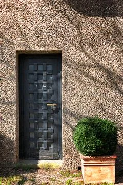 Rustic wooden door with waffle pattern panel, vintage stone wall facade Stock Photos