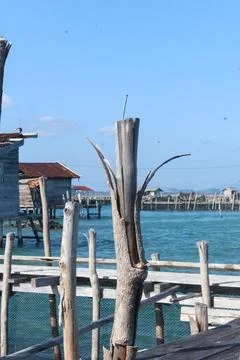Rustic wooden pier structures over turquoise sea water in a traditional coas 库存照片