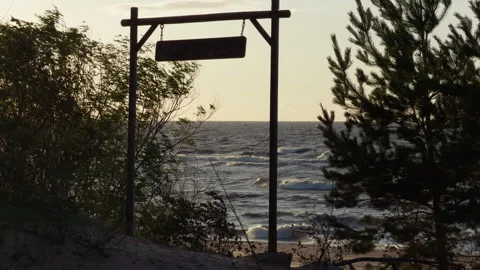 Rustic wooden sign frame overlooking windy beach shoreline with ocean waves at Stock Footage 346558453