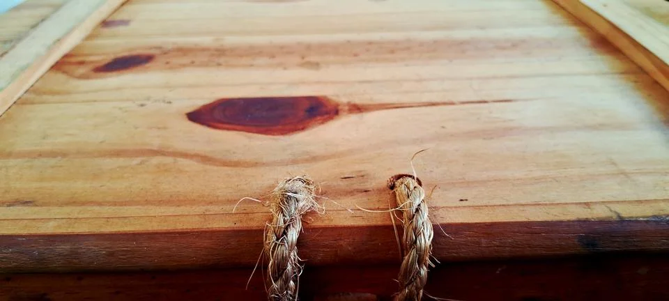 Rustic wooden storage box featuring two braided natural fiber rope handles Stock Photos