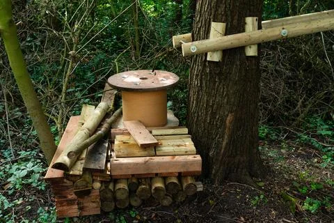 Rustic wooden structure crafted from logs and cylinders in a forest Stock Photos