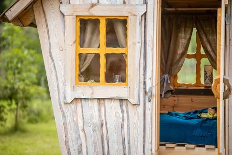 Rustic Wooden Structure with Yellow Window and Open Door Stock Photos