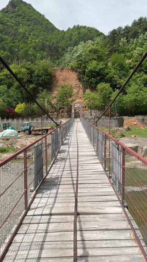 Rustic Wooden Suspension Bridge Spanning River in Qinling Mountains, China Video stock 337278791