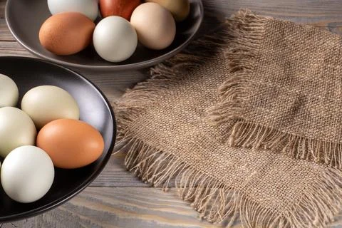 Rustic wooden table displaying vibrant, eco-friendly multicolored chicken egg Stock Photos