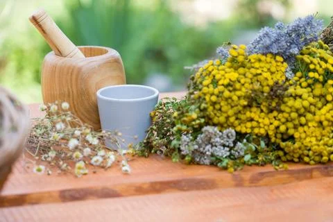 Rustic wooden table features mortar, pestle, and blue cup 스톡 사진