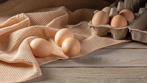 Rustic wooden table setting with close-up of chicken eggs, farm fresh Stock Photos