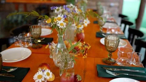 Rustic wooden table setting with wildflowers and fresh fruit Photos