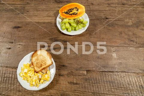 Rustic wooden table, top view and space for text. Plate of toast with eggs. Stock Photos