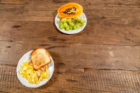 Rustic wooden table, top view and space for text. Plate of toast with eggs. Stock Photos