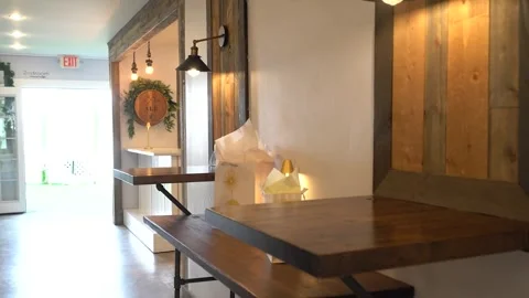 Rustic wooden tables and gift bags beside warm wall sconces Stock Footage 345554889