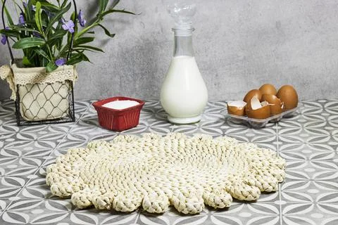 Rustic Woven Placemat on Tiled Kitchen Table With Milk Bottle, Eggs and Baking I Stock Photos