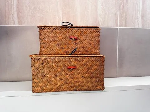 Rustic woven storage baskets stacked on a white shelf in a modern interior .. Stock Photos