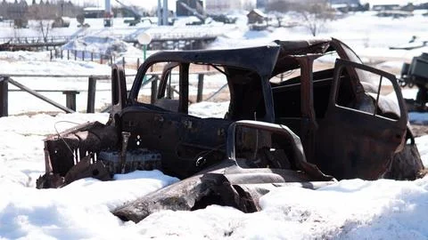 Rusting car shell half buried in snow at rural roadside Fotos de archivo