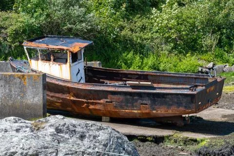 Rusting derelict boat left on a beach Stock Photos