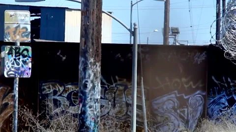 Rusting Graffiti coveredTrain Yard razor wire as freight train passes Stock Footage 58239203