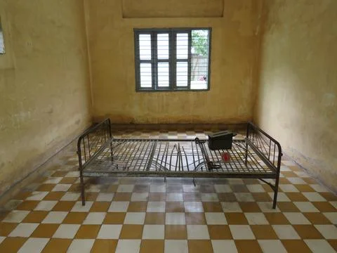 A rusting, metal bed frame inside the Tuol Sleng prison building 写真素材