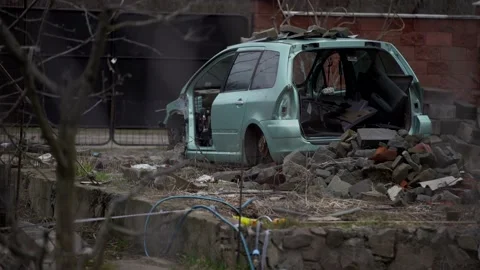 A rusty abandoned car in the parking lot, surrounded by a fence and barbed wire Stock Footage 175362359