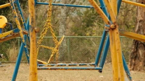 Rusty abandoned playground swinging. Slow Motion Stock Footage 273465764