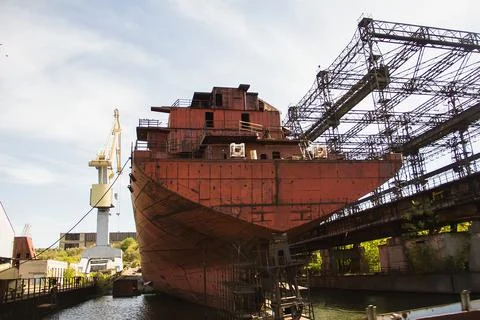 Rusty, abandoned ship under construction, unfinished ship at the factory. Stock Photos