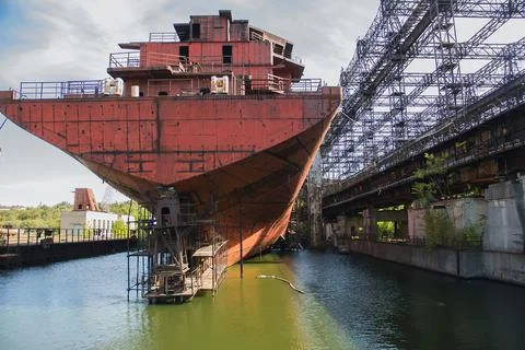Rusty, abandoned ship under construction, unfinished ship at the factory. Stock Photos