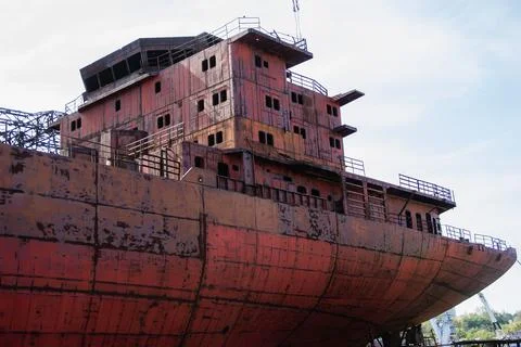 Rusty, abandoned ship under construction, unfinished ship at the factory. Stock Photos