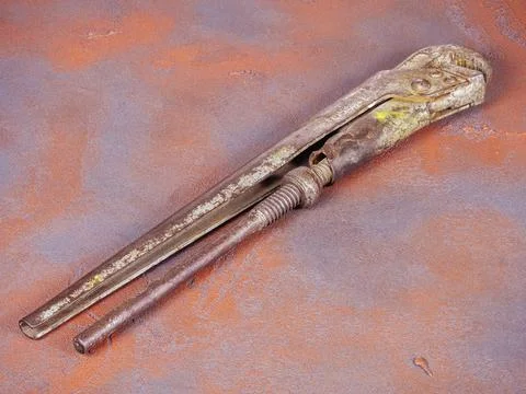Rusty adjustable spanner on a grunge orange background Stock Photos