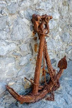 Rusty anchor next to stone wall in Camogli Stock Photos