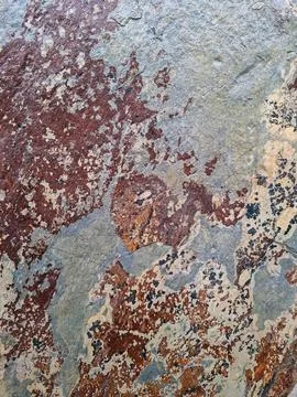 Rusty and black stone wall tiles create a textured surface in a simple, nat.. Stock Photos