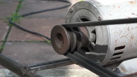 Rusty and old water pump motor working, Rotating pulley and belt on air pump  Stock Footage 130893070