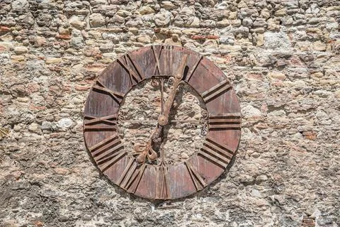 Rusty antique clock on the wall. Stock Photos
