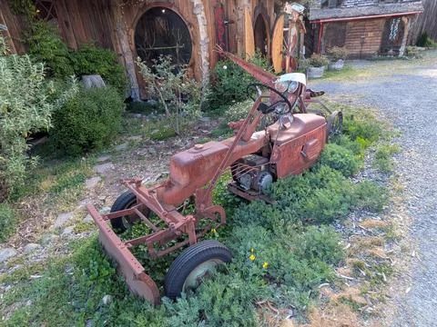 Rusty antique farm machine with scrap-metal figure Stockfoto's