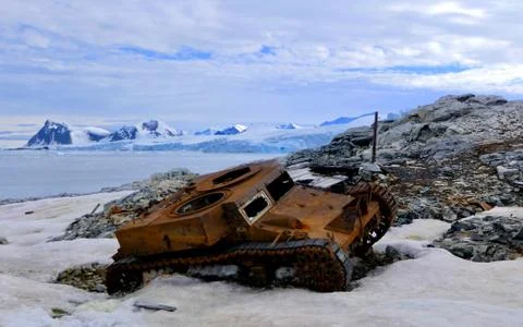 Rusty armored vehicle wreck in Antarctica with glacier in background Stock Photos