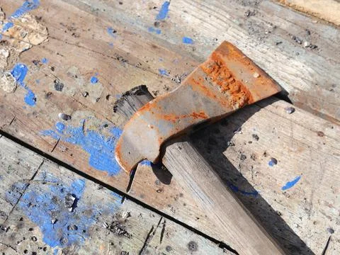 A rusty axe is lying on the table. The blade is clearly visible Foto stock
