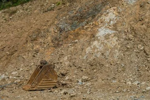 Rusty backhoe bucket at hillside Stock Photos