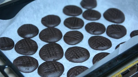 Rusty baking sheet laying on the wood table. There are some chocolate cookies on Видео 92312715