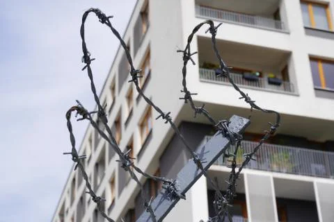 Rusty barbed wire on the background of a modern residential building. contras Stock Photos