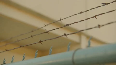 Rusty Barbed Wire With Prison in the background. Stock Footage 170074123